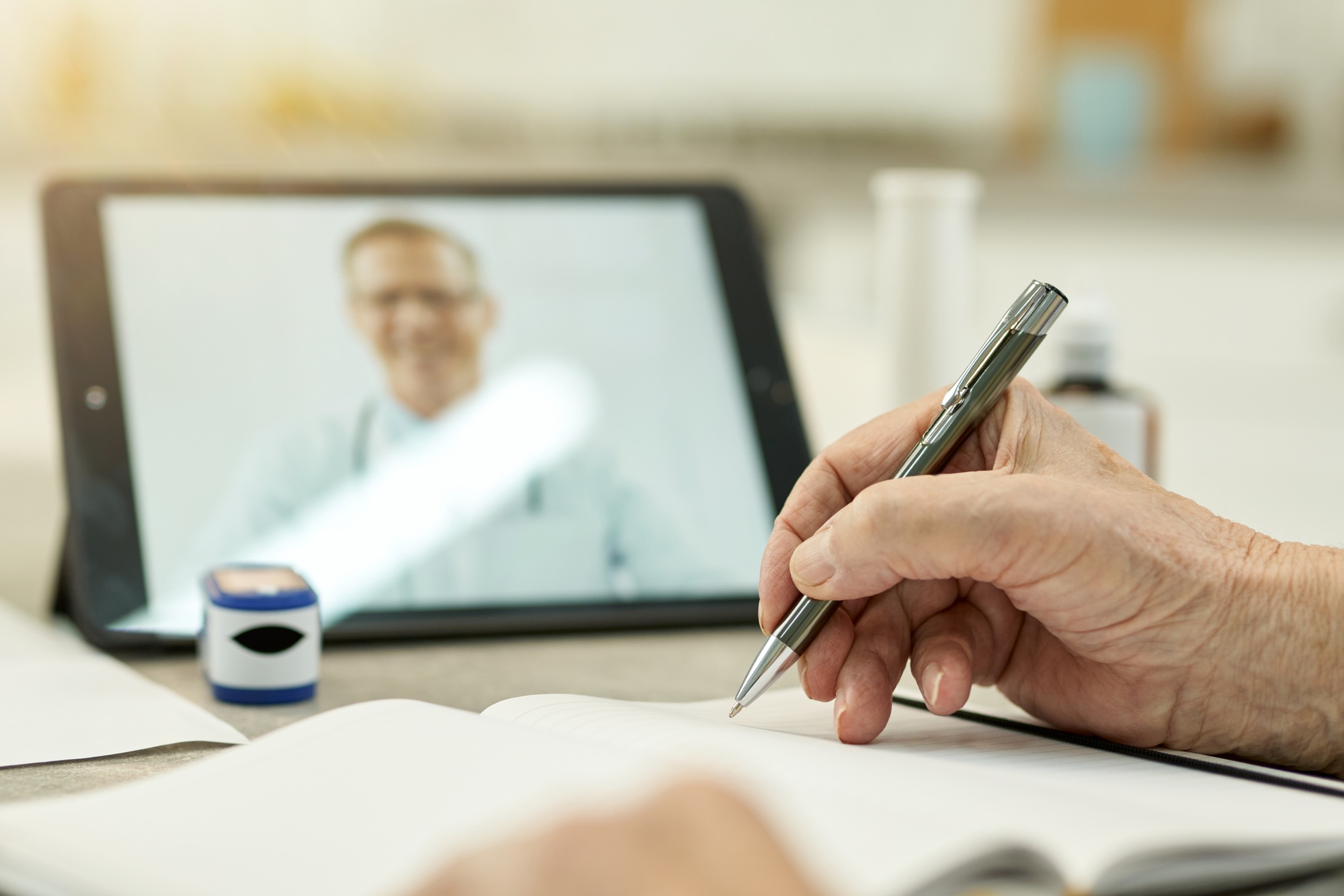 Mindful patient taking notes during online medical consultation